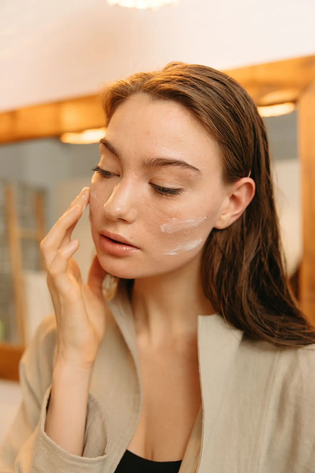 Vrouw brengt kalmerende creme aan als dagelijkse rosacea huidverzorging